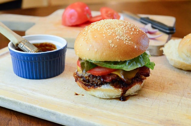 Stout & Sriracha Barbecue Bacon Burgers on a cutting board.