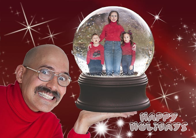 A man wearing glasses and holding a snow globe