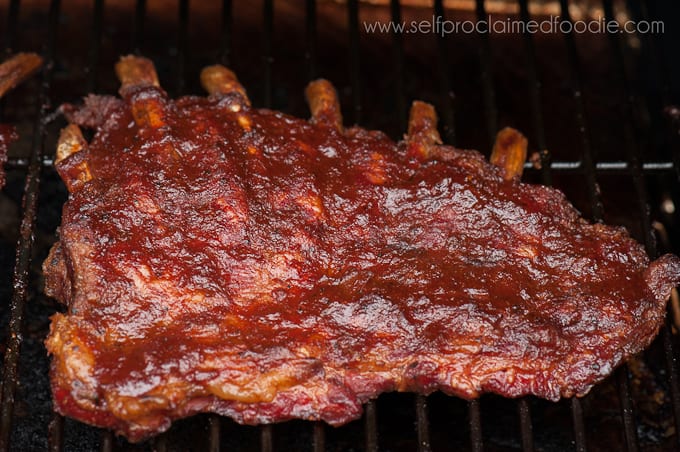 slab of sauce covered ribs on a grill