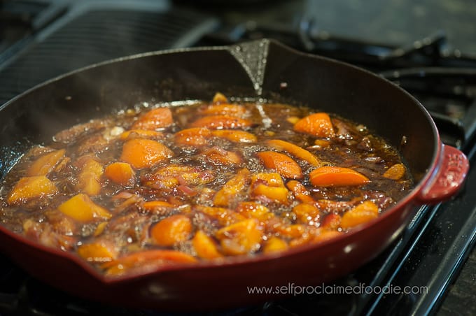 A pan of apricots cooking in sauce