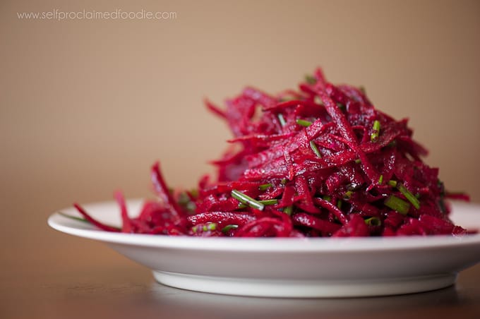 raw beet salad with citrus vinaigrette on white plate