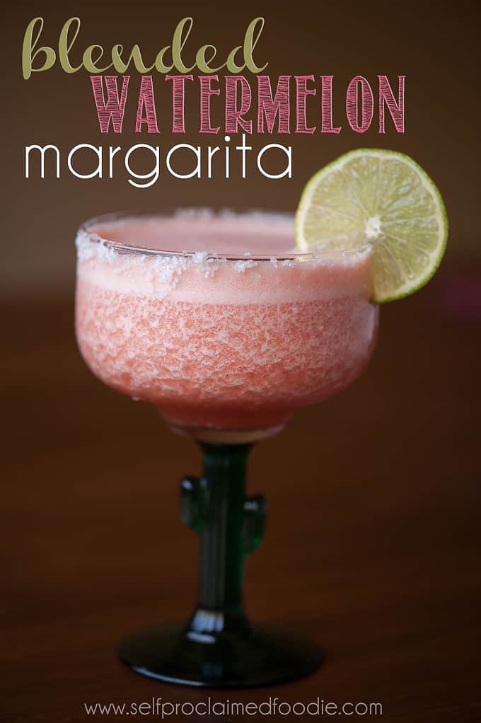 a glass of blended watermelon margarita with lime garnish