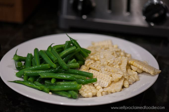 plate of fresh green beans and corn cut from cob