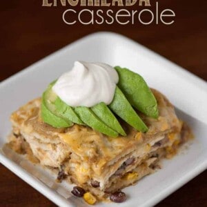 green chile enchilada casserole on plate topped with avocado and sour cream
