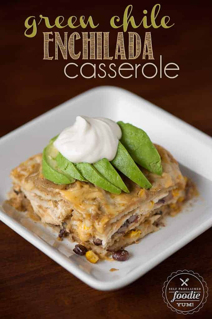 green chile enchilada casserole on plate topped with avocado and sour cream