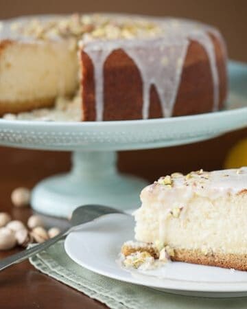 This sweet and rich Lemon Pistachio Cake is sure to impress with its pistachio cookie crust, melt-in-your-mouth lemon cake, and lemon zest icing.