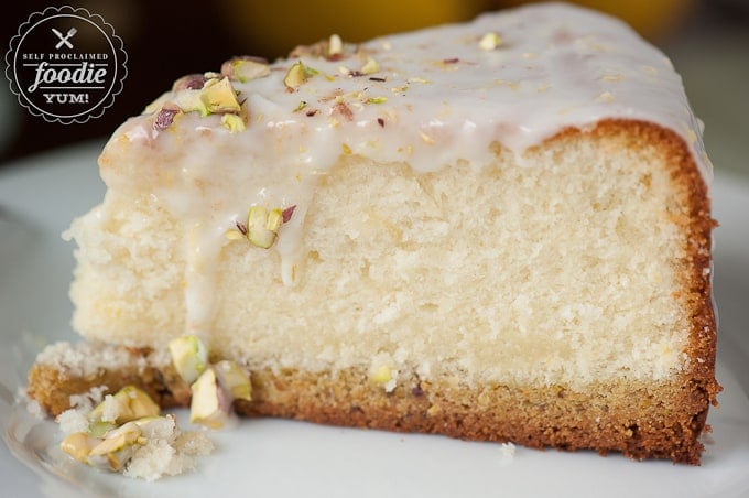 a close up of a slice of glazed pistachio lemon cake