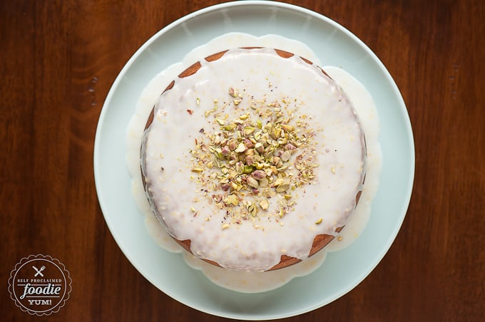 looking down at lemon pistachio cake with icing on green plate