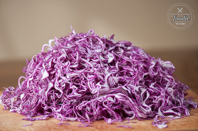 pile of shredded red cabbage on brown cutting board