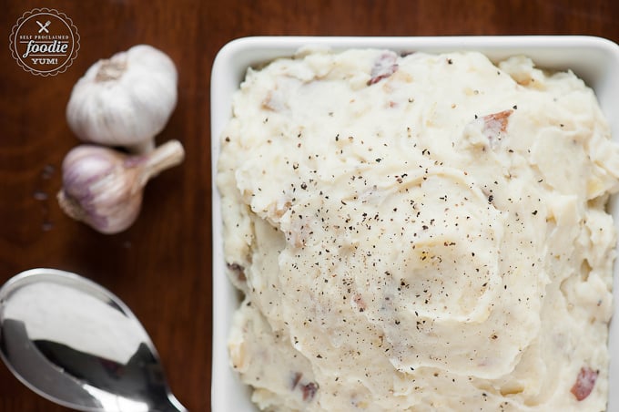 mashed potatoes in square dish with garlic on side