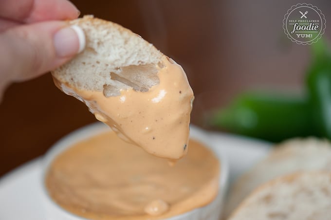 dipping bread slice into warm bacon jalapeno fondue