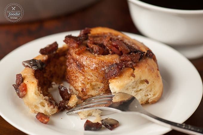 homemade cinnamon roll on plate with bacon and maple glaze