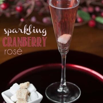 champagne flute with sparkling cranberry rose cocktail with sugar cubes