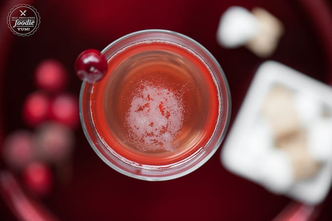looking down at sparkling cranberry rose in glass with cranberry garnish