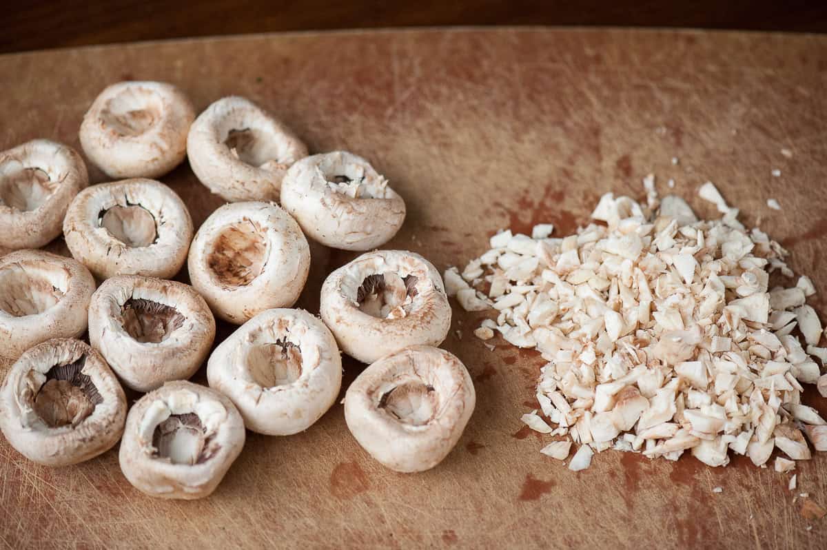 chopped mushroom stems next to mushroom caps.