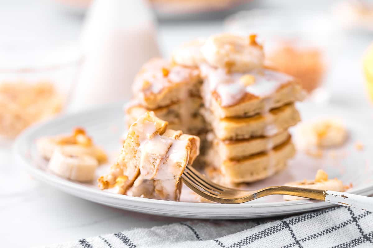 Hawaiian-style fluffy pancakes with coconut syrup and bite cut out.