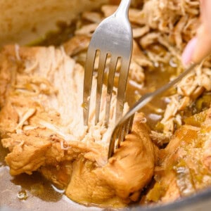shredding chicken breasts with forks for green chile chicken stew.