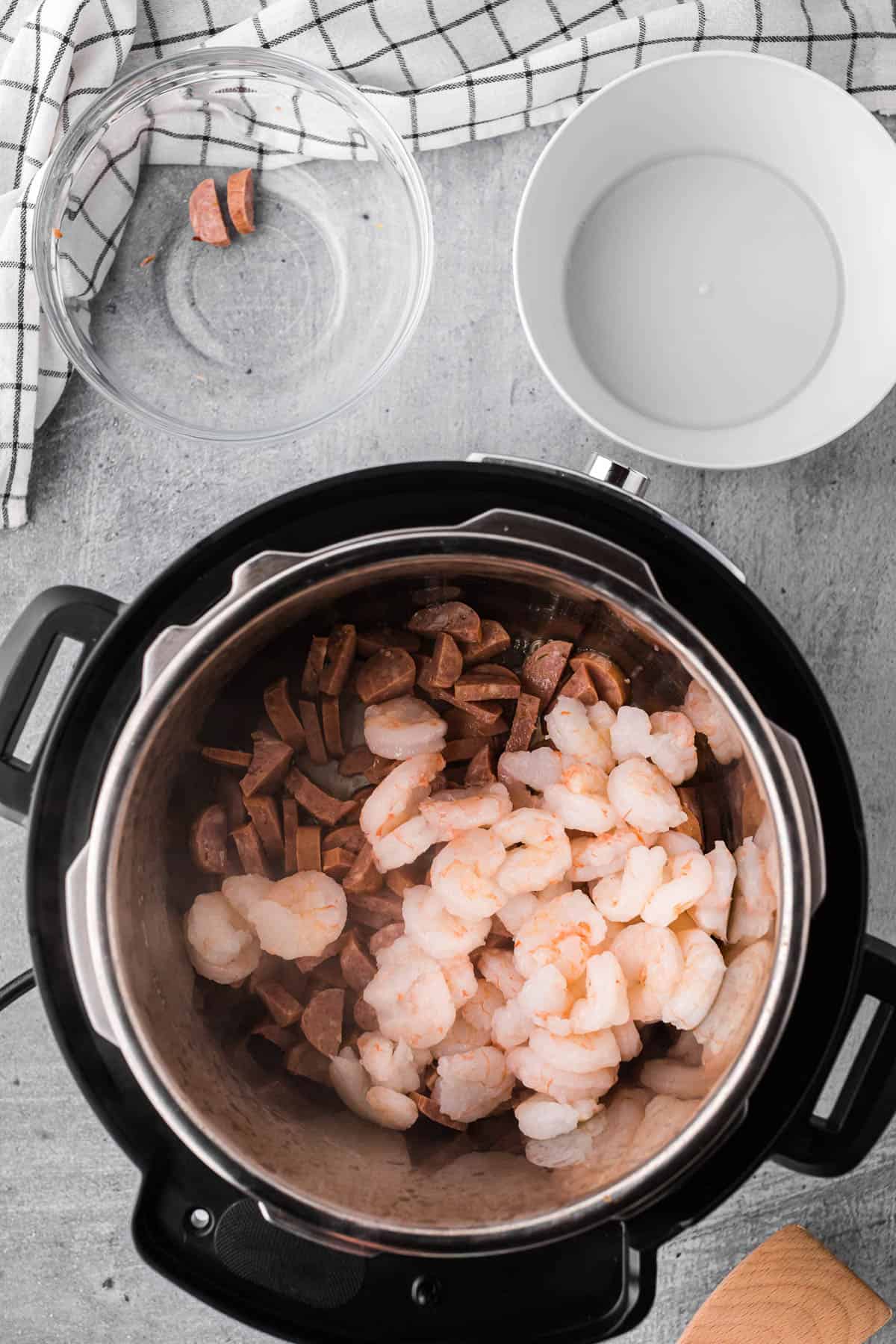 Adding shrimp and sausage to Instant Pot for Jambalaya recipe.