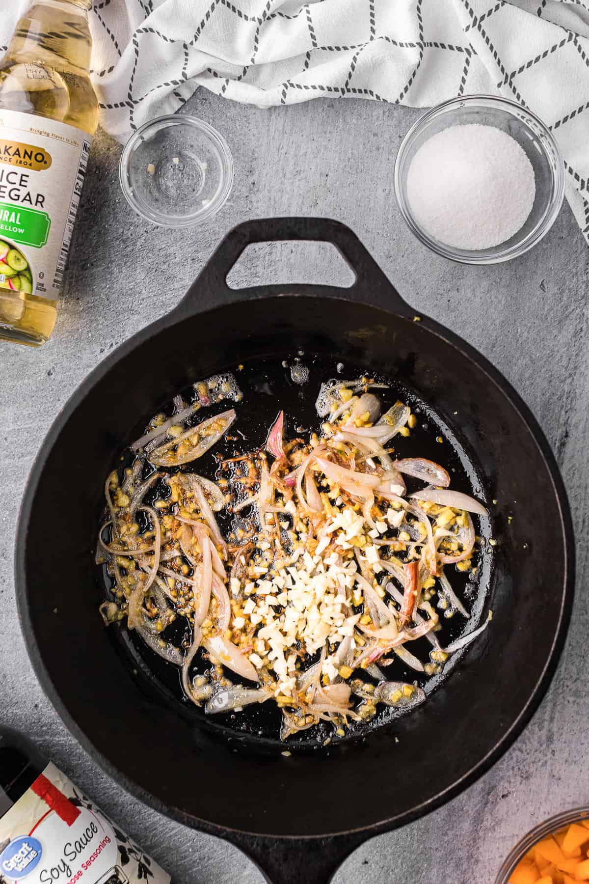 cooking shallots and garlic in pan for fresh apricot glaze recipe.