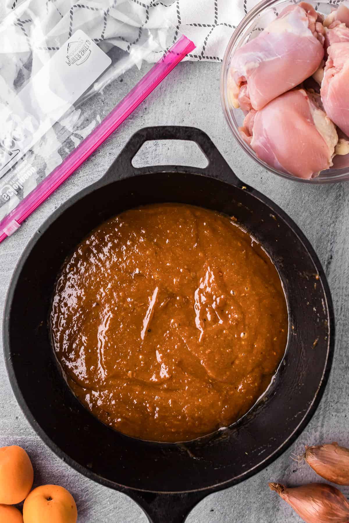 pureed fresh apricot glaze in saucepan and a bowl of boneless skinless chicken thighs.