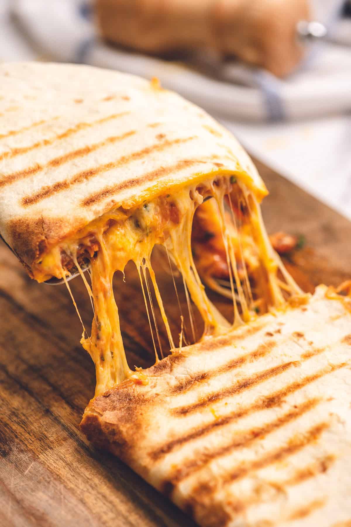 melty cheese pulling in between two pieces of a chipotle chicken quesadilla.