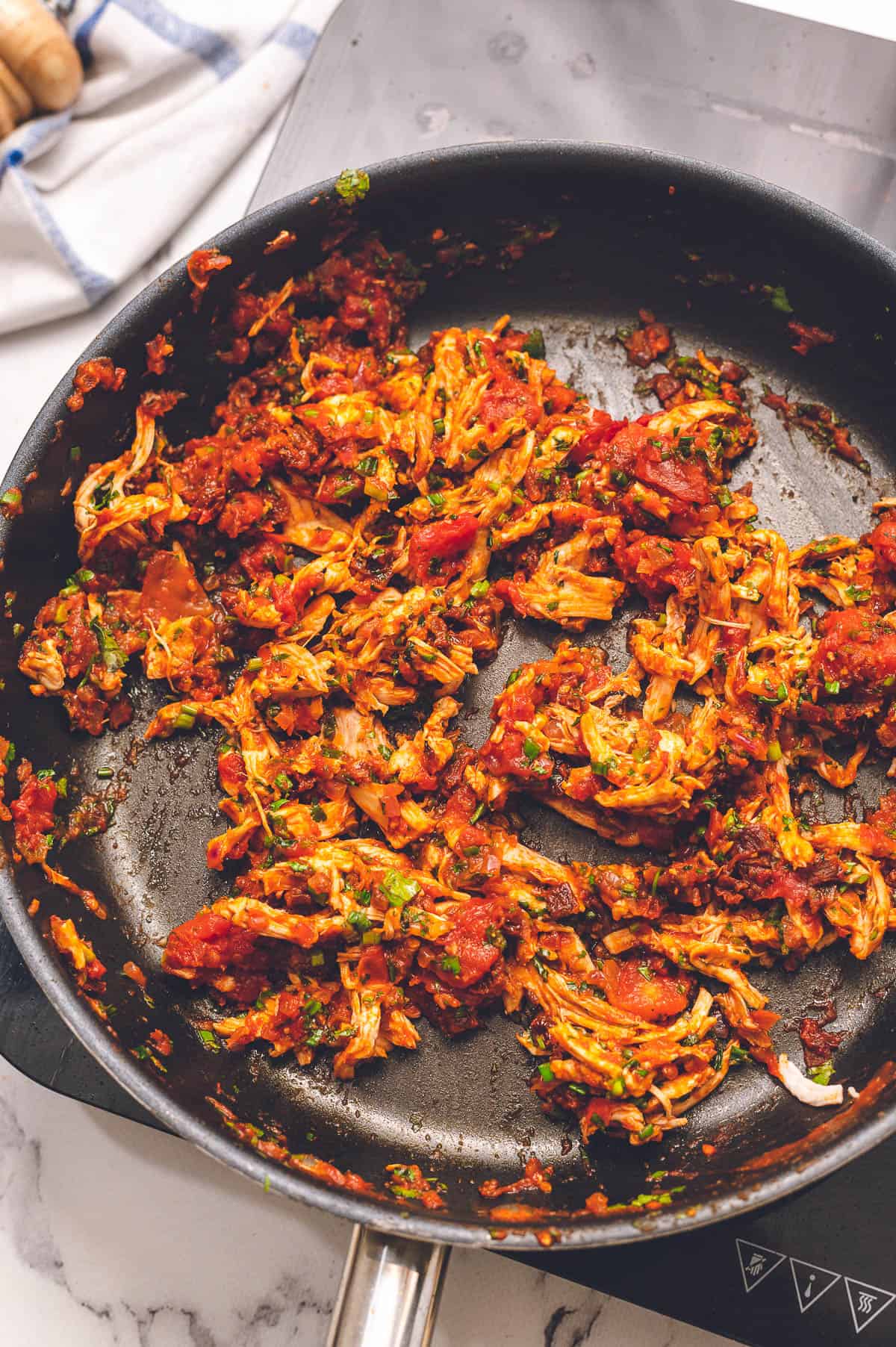 chipotle chicken mixture with tomatoes in pan.