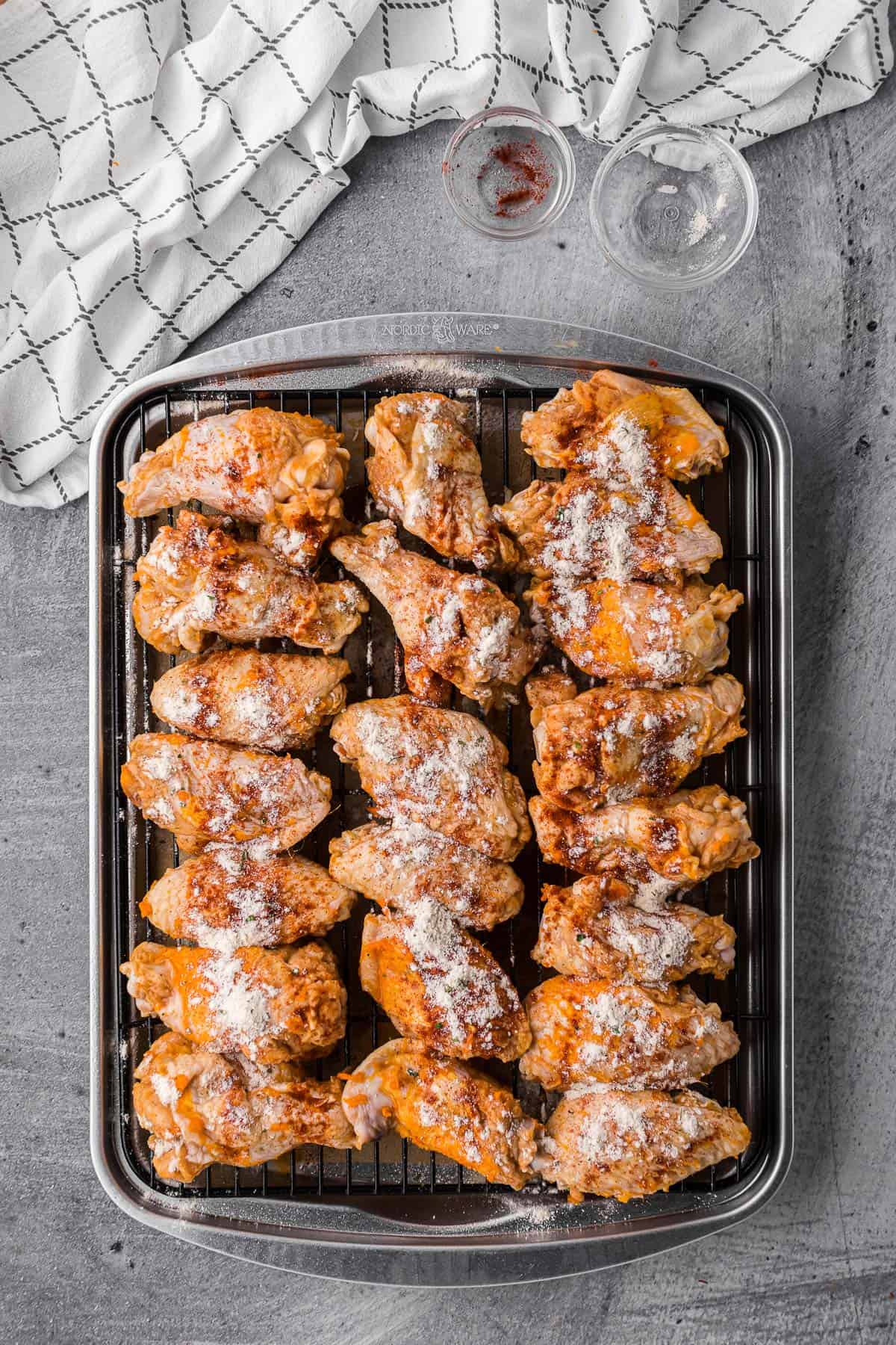 marinated chicken wings sprinkled with ranch seasoning about to be baked in oven.