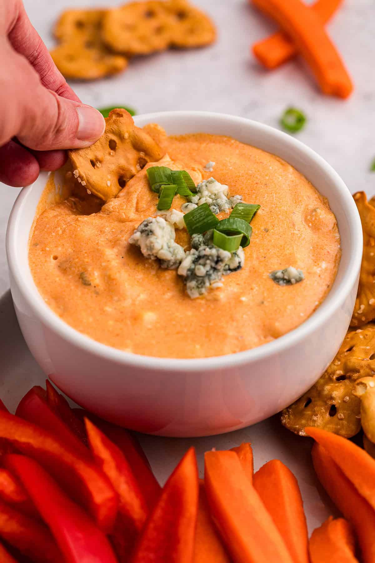 Dipping a pretzel thin into homemade warm buffalo chicken dip.