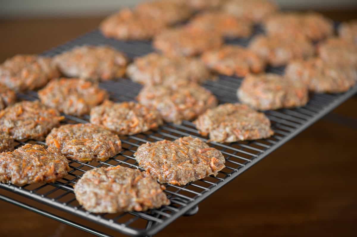 freshly baked carrot cake cookies on cooling rack.