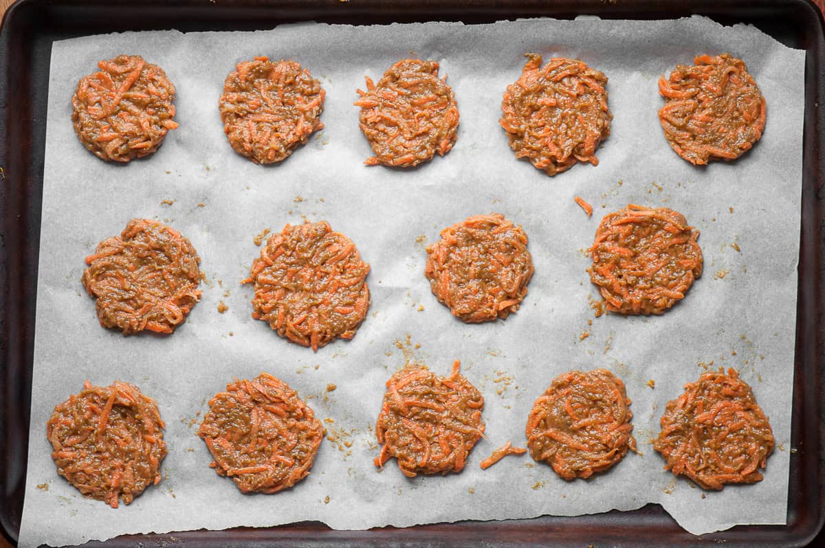 uncooked carrot cake cookies on parchment lined baking sheet.