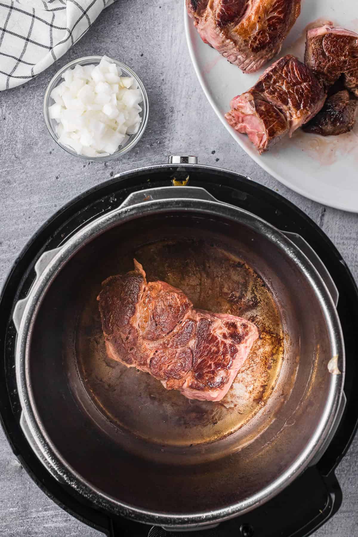 searing a large piece of beef chuck roast in an instant pot.