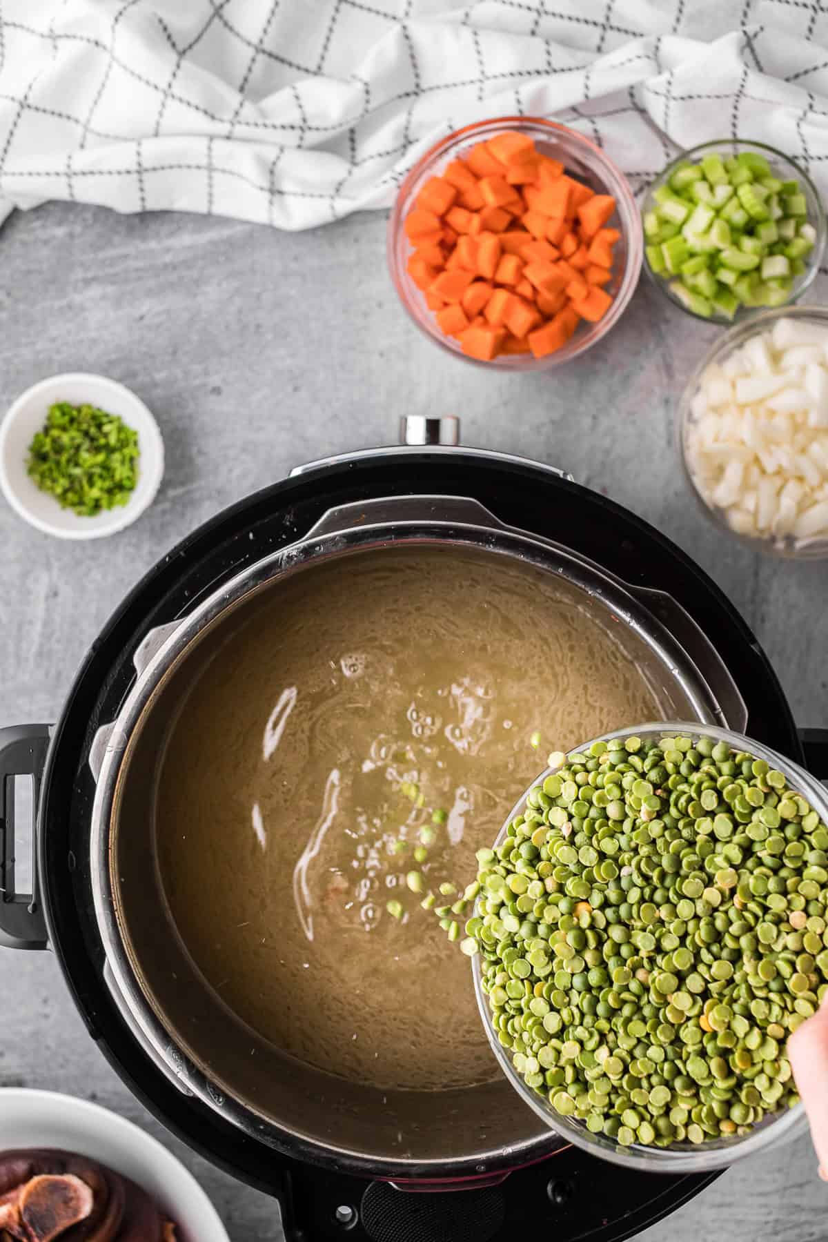 Adding dried split peas to liquid.