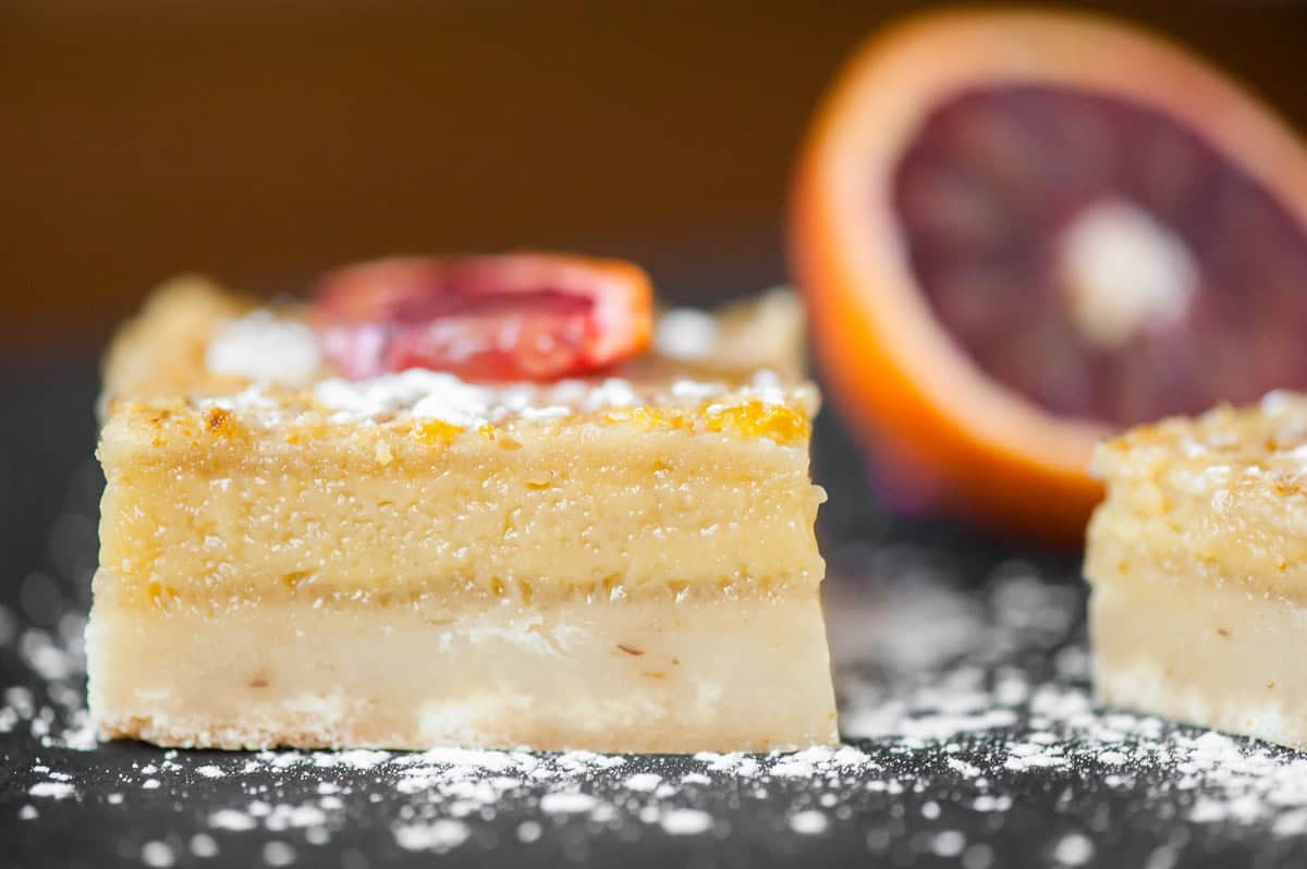 side view of homemade Orange bars dusted with powdered sugar.