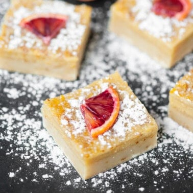 Orange bars dusted with powdered sugar.