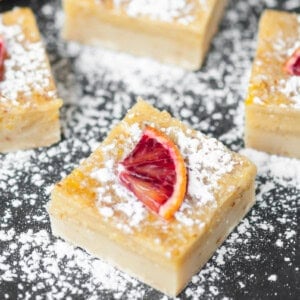 Orange bars dusted with powdered sugar.