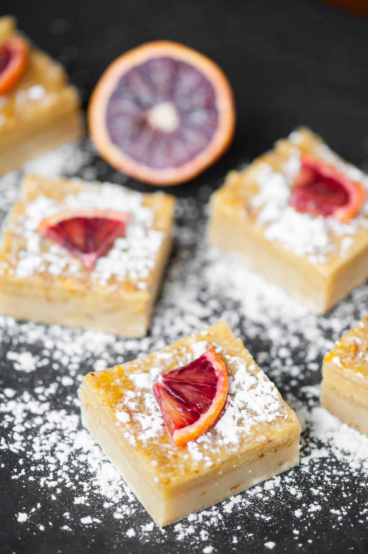 Orange bars dusted with powdered sugar.