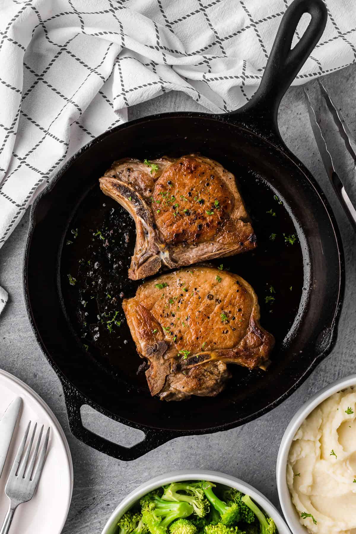 pan seared salt and pepper pork chops in cast iron pan.