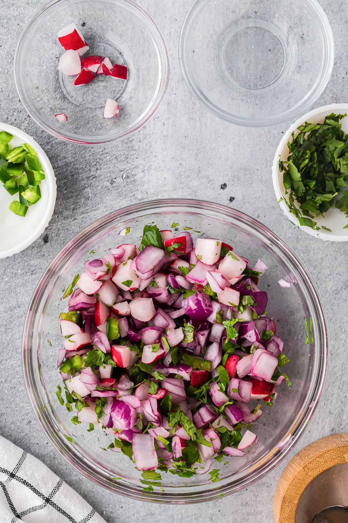 Combining chopped ingredients in bowl to make quick pickled radishes.