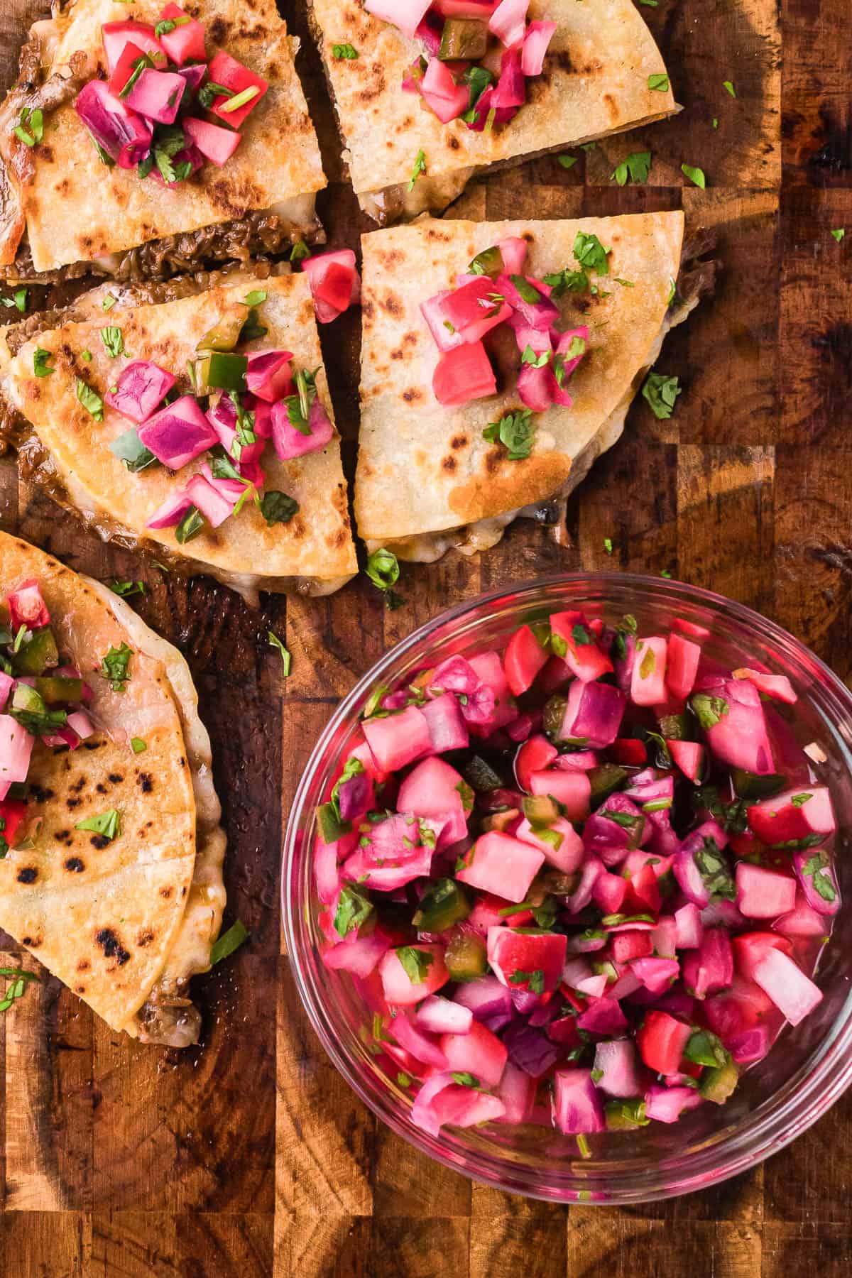 bowl of quick pickled radishes next to crispy quesadillas.