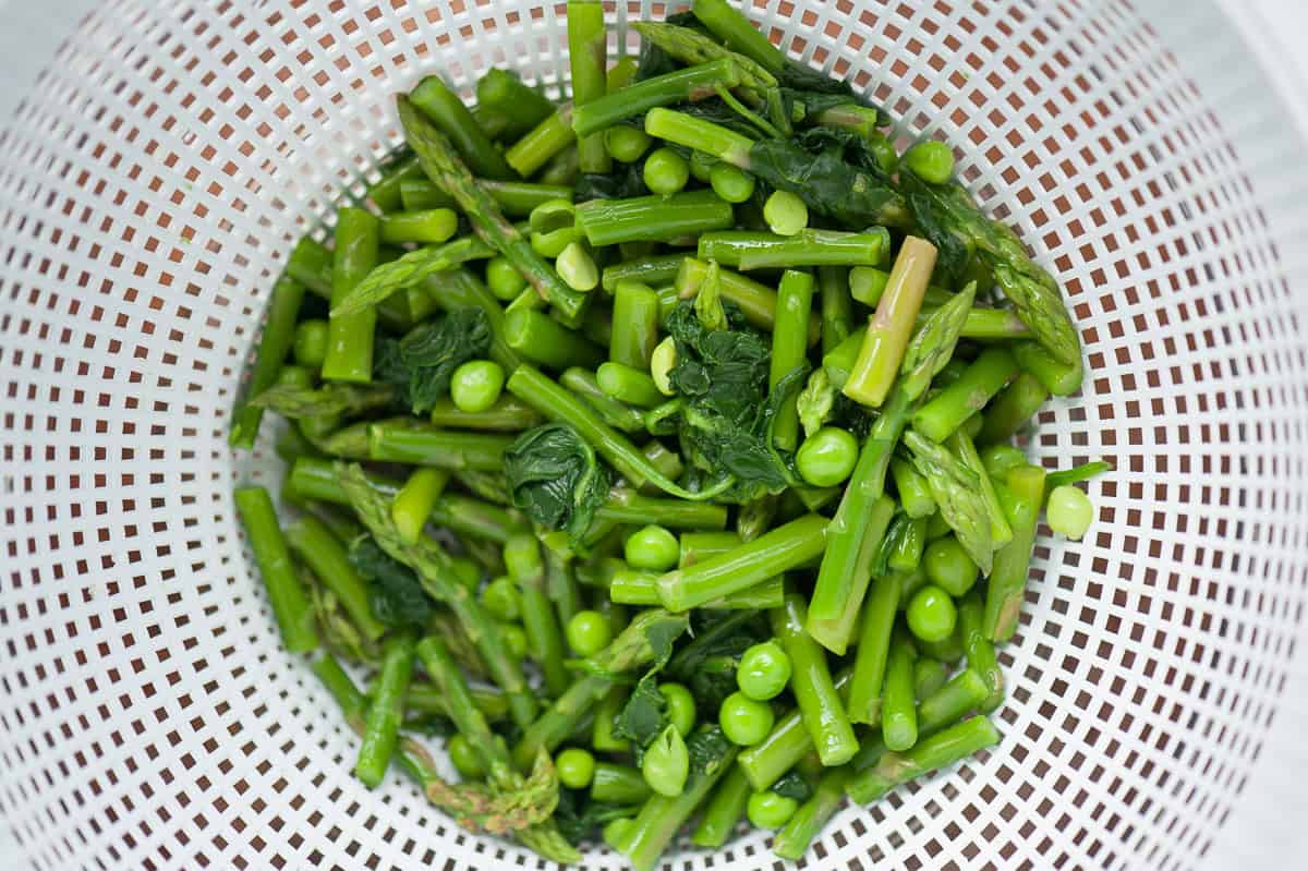 straining blanched spring vegetables.