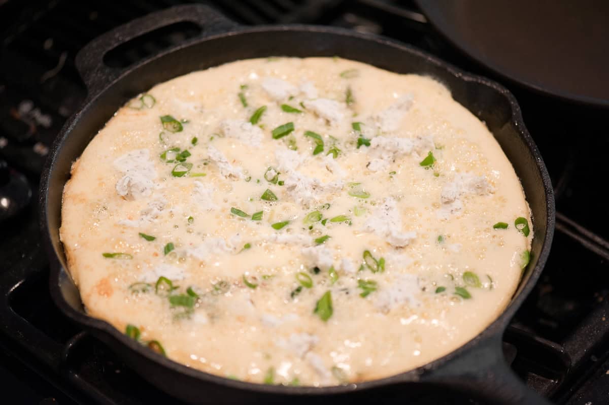 cooking a frittata in a cast iron skillet.