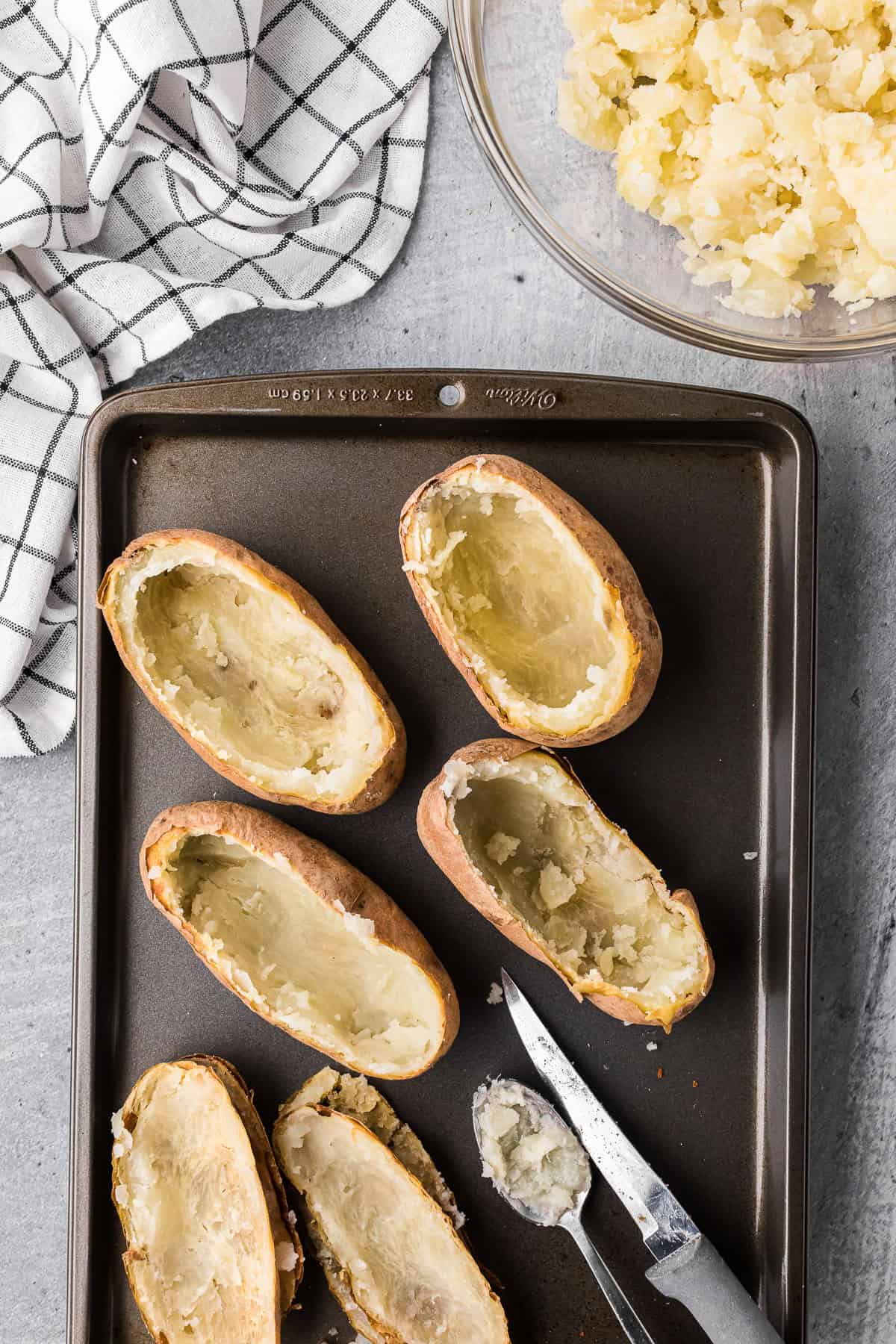 baked potatoes that have been cut in half with inside scooped out.