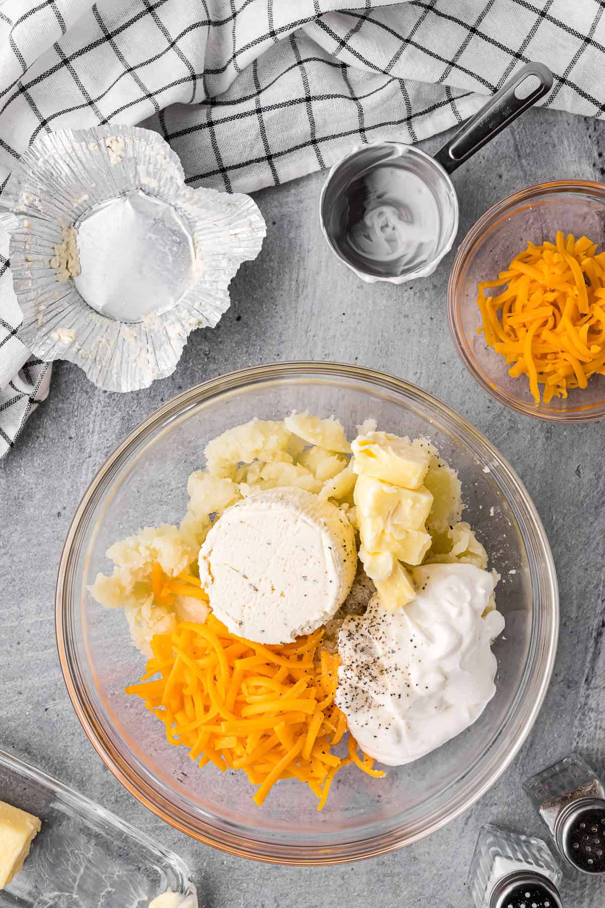 mixing baked potato with cheeses and butter.