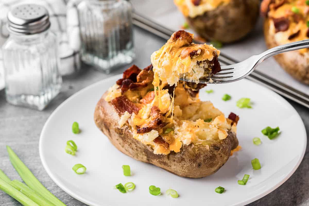 taking a fork bite out of twice baked potatoes.