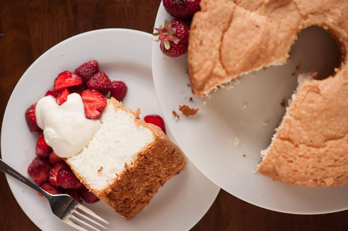 homemade angel food cake with strawberries and whipped cream.