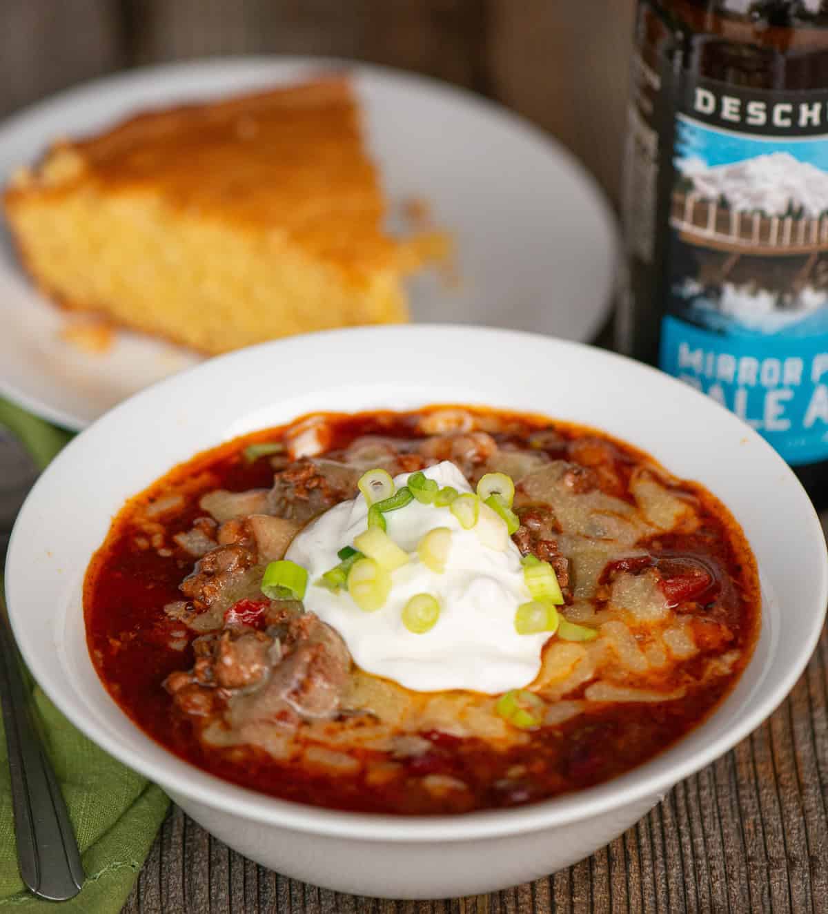 beer chili topped with cheese, sour cream, and green onions.