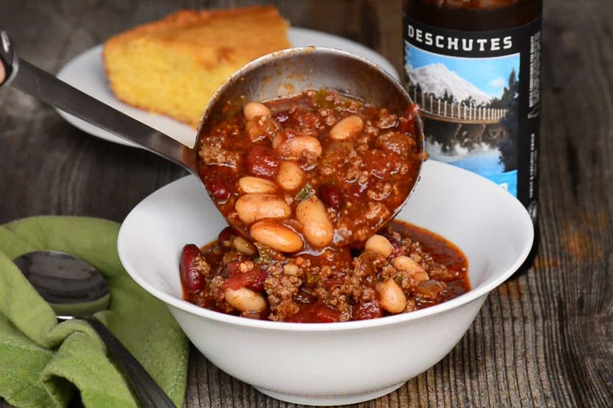 adding beer chili to a bowl.