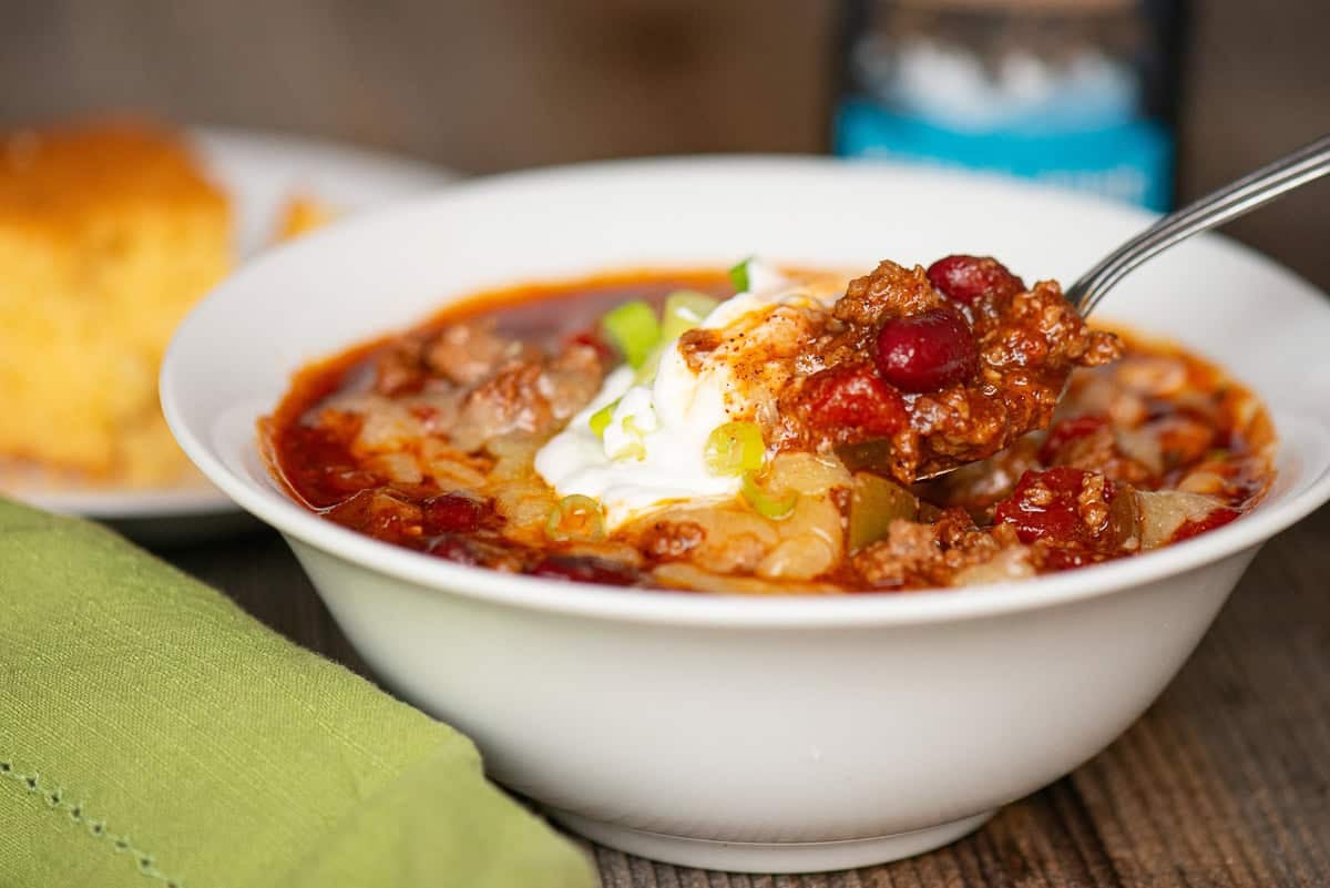 beer chili topped with cheese, sour cream, and green onions.