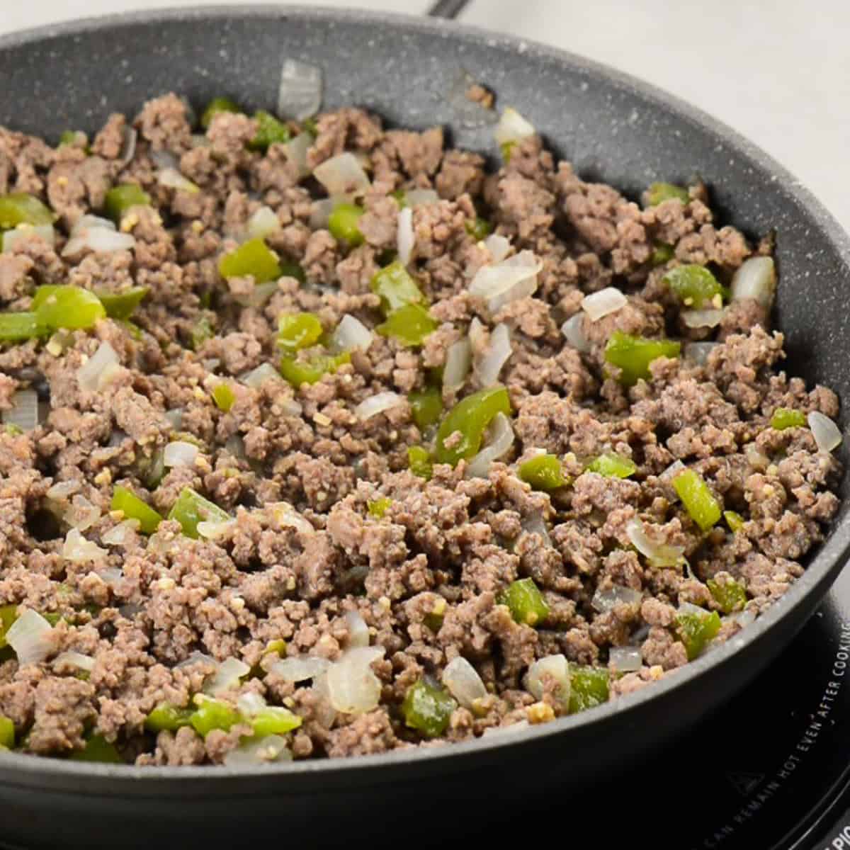 cooking ground beef with onions and peppers.