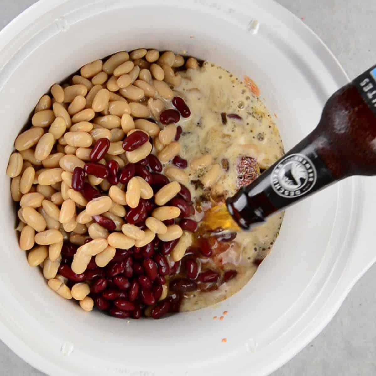 adding beer to slow cooker for chili recipe.